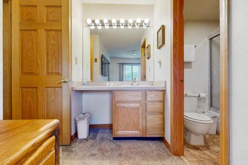 a bathroom with a sink and a toilet and a mirror at Snowdance Condo A101 in Keystone