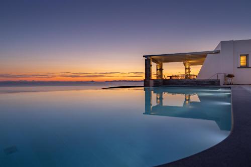 a villa with a swimming pool at sunset at Villa Kouneli - an exceptional holiday in Koundouros