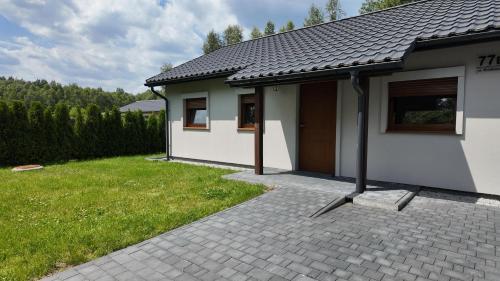 a small house with a patio and a grass yard at Domek -Radawa-Królewska 77b,domek Dorota in Radawa