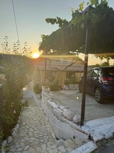 a car parked in front of a house with the sunset at Basil & Sunrise in Lazaráta