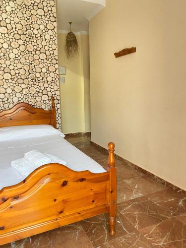a bedroom with a wooden bed in a room at La Vega Rooms in Huelva