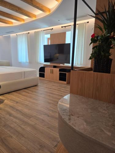 a living room with a bed and a television at Palorto Inn in Gjirokastër