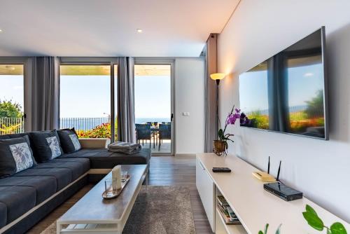 a living room with a couch and a table at Villa Pinheira IV -Heated swimming pool and jacuzzi in Calheta