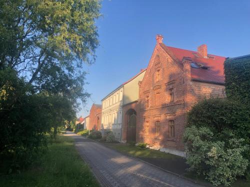 an old brick building on the side of a road at Amselwohnung in Lübs