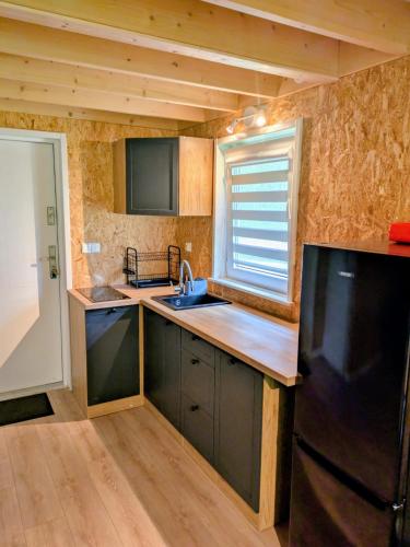a small kitchen with a sink and a refrigerator at Domek Letniskowy Zefirek in Nowy Dwór