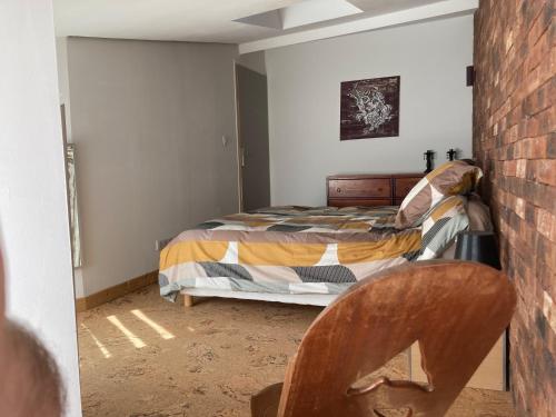 a bedroom with a bed and a chair at L'atelier du faubourg in Châlons-en-Champagne
