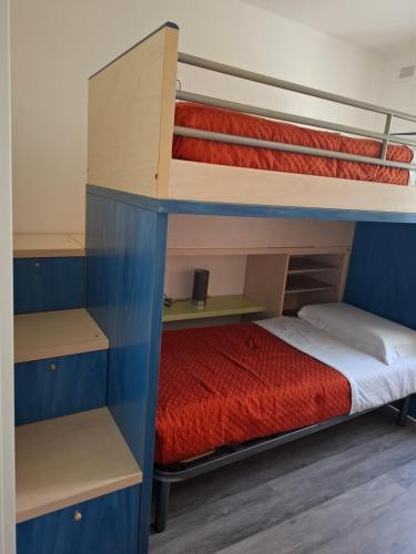 two bunk beds in a room with a red bed at Casa ai due Ulivi in Nago-Torbole