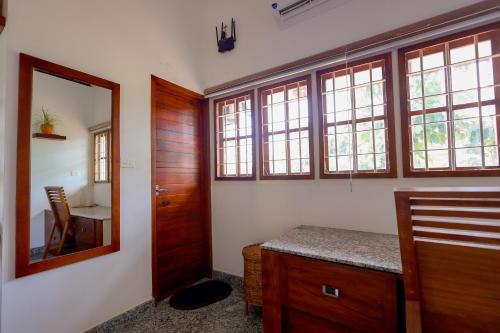 a bathroom with a vanity and a mirror and a sink at Nellu - Tranquil Pool Villa & Organic Farmstay near Varkala in Trivandrum