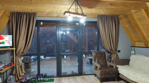 a living room with a couch and a large window at Carpathian A-frame in Dragoslavele
