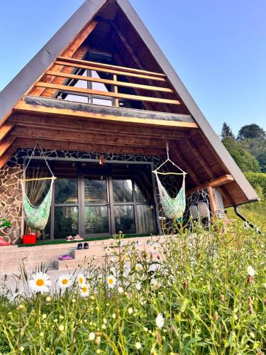 a house with two hammocks on the front of it at Carpathian A-frame in Dragoslavele