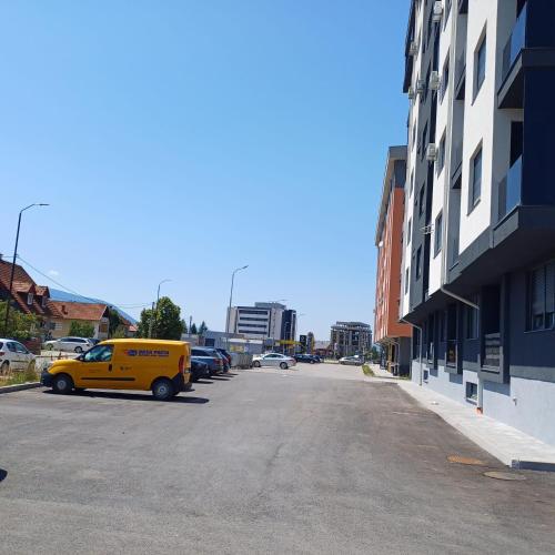 a yellow van parked in a parking lot next to a building at Wellness & Spa Red Paradise in Donje Mladice