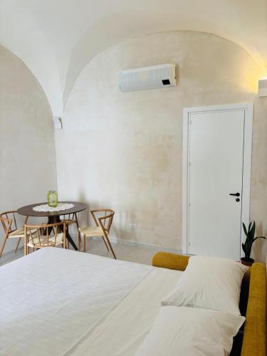 a bedroom with a bed and a table with chairs at Casa Petra - Santa Croce in Lecce