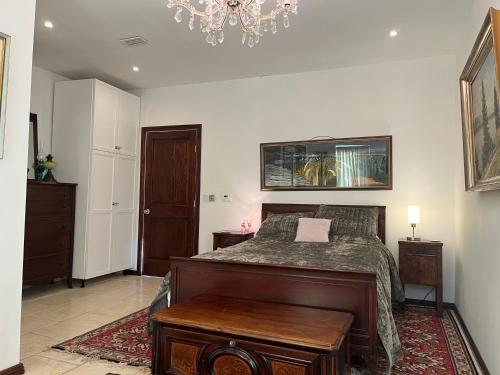 a bedroom with a bed and a chandelier at West Colla Place in Schull