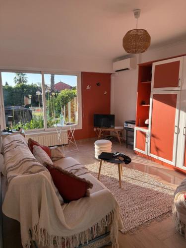 un salon avec un canapé et une grande fenêtre dans l'établissement Antibes La Louisiane 2 Pieces rez-de-jardin Piscine, à Antibes