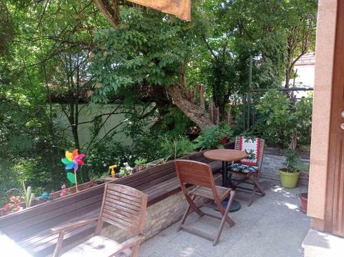 a wooden bench with two chairs and a table at ABAGuesthouse in Sarajevo