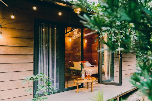 a screened in porch of a house with a table at Căn Gỗ in Sóc Sơn
