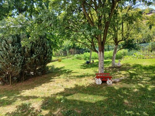 a small red train sitting next to a tree at Rooms-Zejnep SARAJEVO in Sarajevo