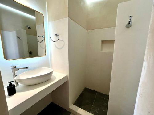 a white bathroom with a sink and a mirror at La Ventana Hostel in La Ventana