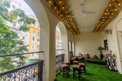 a room with a balcony with chairs and green grass at Social Safari Hostel, PARK STREET in Kolkata