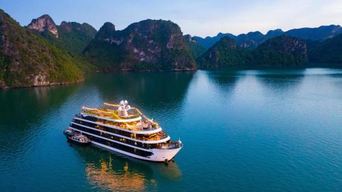 a cruise ship in the water with mountains in the background at Venus Cruises Halong Bay in Ha Long