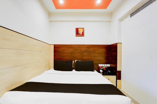 a bedroom with a large bed with a wooden headboard at Super Townhouse Chennai Near Airport Formerly Sai Bala Budget in Chennai
