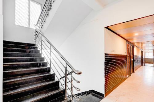 a staircase in a house with black stairs at Super Townhouse Chennai Near Airport Formerly Sai Bala Budget in Chennai