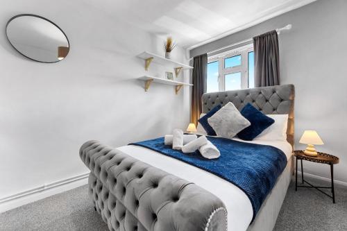 a bedroom with a large bed with a large window at South Stays in London