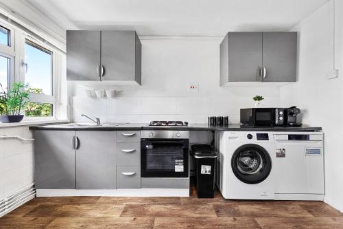 a kitchen with a washing machine and a washer at South Stays in London