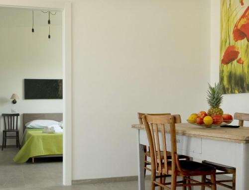 a dining room with a table with a bowl of fruit at Masseria Luci Grande in Scorrano