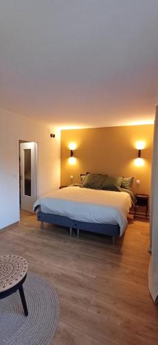 a bedroom with a bed with two lamps on the wall at L'Aubier in Saint-Maur