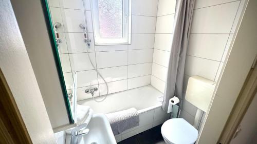 a white bathroom with a shower and a toilet at Between City&Nature in Herzogenrath
