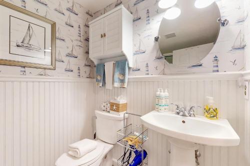 Un baño con lavabo, inodoro y espejo. en Sail Away, en Harwich