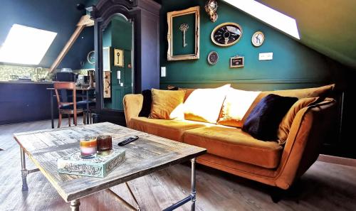 un salon avec un canapé et une table dans l'établissement LES CLES DES REMPARTS - Appartement privé à thème tout équipé - Atypique - Centre Saint-Lô - Gare - Haras - Parking public gratuit - Entrée autonome - Wifi - Netflix - TV XXL - Lit 160x200, à Saint Lo