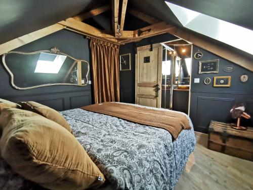 圣洛LES CLES DES REMPARTS - Appartement privé à thème tout équipé - Atypique - Centre Saint-Lô - Gare - Haras - Parking public gratuit - Entrée autonome - Wifi - Netflix - TV XXL - Lit 160x200的一间卧室，墙上有一张床和一台电视