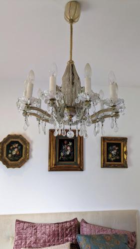 a chandelier in a living room with pictures on the wall at West Colla Place in Schull