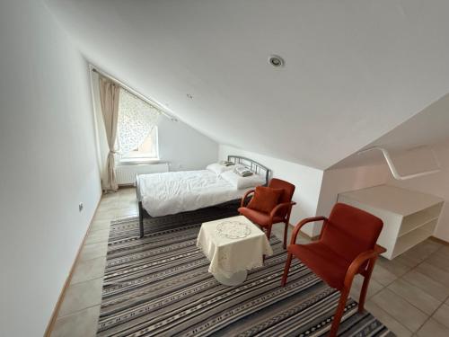 a bedroom with a bed and two chairs and a desk at Lotta autobus na targi MTP, darmowy parking, samodzielny meldunek in Poznań