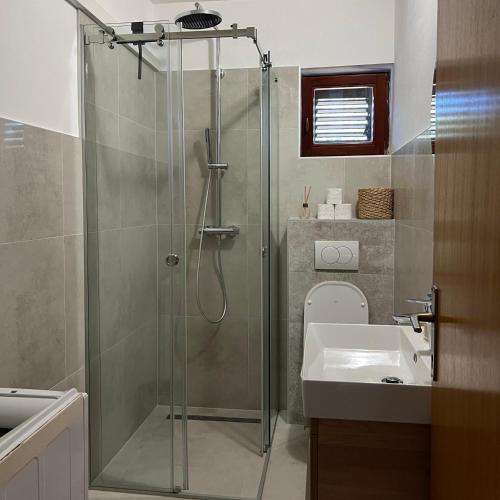 a bathroom with a shower and a sink at Apartmani Predovan in Vrsi