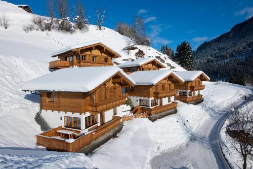 a group of wooden cabins in the snow at Tauernchalets in Grossarl