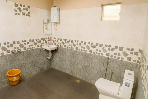 a bathroom with a toilet and a sink at Hippla Homestay in Aldūr