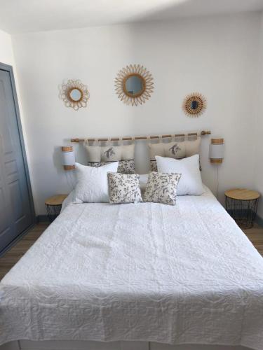 - une chambre avec un grand lit et deux miroirs sur le mur dans l'établissement Appartement des Gabarres, à Bergerac