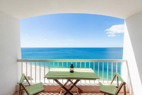 a table on a balcony with a view of the ocean at O som das ondas - vista soberba de mar in Sesimbra