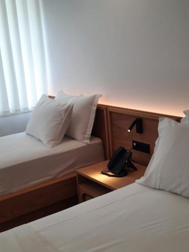 a bedroom with two beds and a phone on a table at Palorto Inn in Gjirokastër