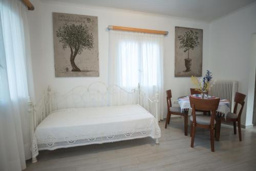 a bedroom with a white bed and a table and chairs at Velanidia House in Lygia