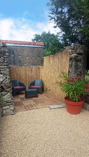 d'une terrasse avec 2 chaises bleues et un mur en pierre. dans l'établissement Entre ciel et Sèvre, à Treize-Vents