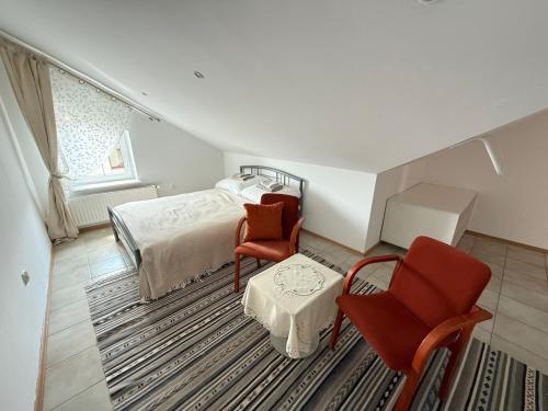 a bedroom with a bed and two chairs and a table at Lotta autobus na targi MTP, darmowy parking, samodzielny meldunek in Poznań
