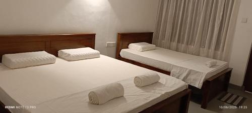 a bedroom with two beds with towels on them at Villa Senowin in Anuradhapura