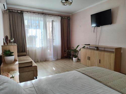 a bedroom with a bed and a television on the wall at Однокімнатна на Троєщині in Kyiv