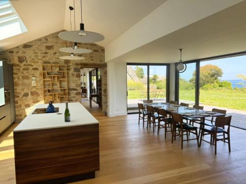 a kitchen and dining room with a table and chairs at Villa Les Embruns sea view Beg Ar Fry 10 people in Guimaëc