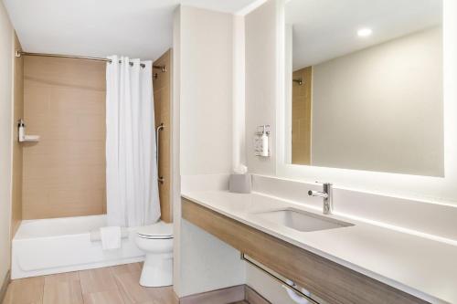 a bathroom with a sink and a toilet and a mirror at Holiday Inn Express & Suites Jacksonville South East - Medical Center Area by IHG in Jacksonville
