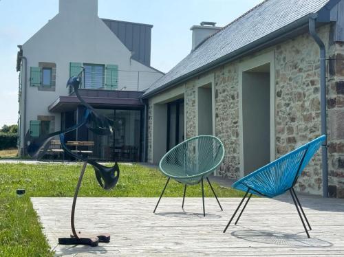 two chairs sitting in front of a house at Villa Les Embruns sea view Beg Ar Fry 10 people in Guimaëc